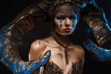 Boynuz siyah bir zemin üzerine Cadılar Bayramı için elbiseli güzel ince kız