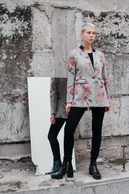 Beton duvar yakınında sokakta kısa saçlı şık ve güzel kız