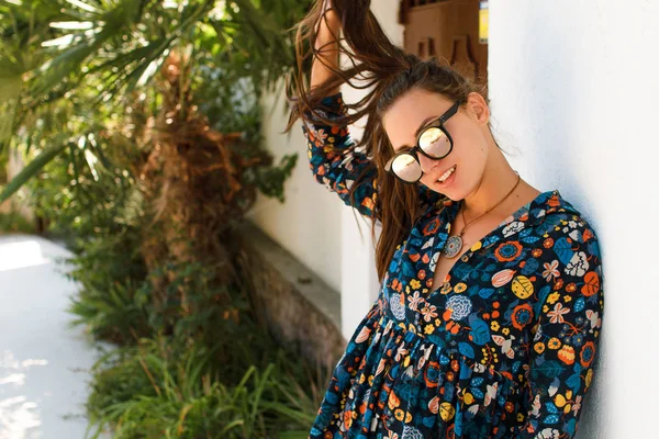 Hermosa chica con una sonrisa en gafas sobre un fondo de palmas — Foto de Stock