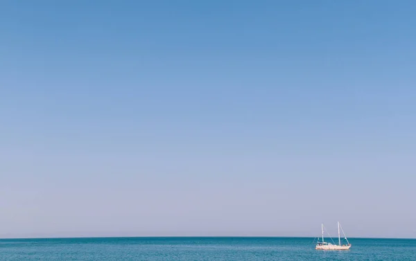 Яхта плавает в океане на горизонте — стоковое фото