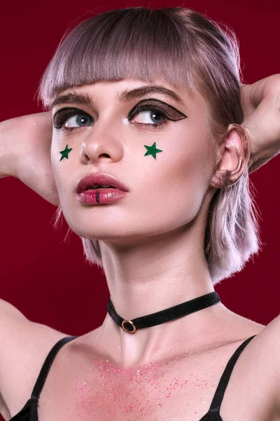 Sarı saçları ve makyaj kırmızı arka plan ile güzel kız 