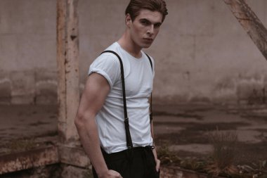 Yakışıklı ve şık bir adam eski terkedilmiş sokaklarda yürüyor