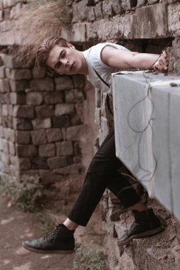 Yakışıklı ve şık bir adam eski terkedilmiş sokaklarda yürüyor