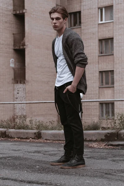 A handsome and stylish guy walks the old abandoned streets