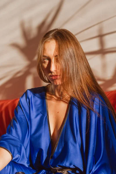 Beautiful girl in blue silk robe resting in the sunlight