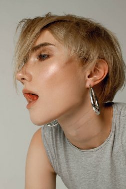 Beyaz bir arka planda beyaz bir T-shirt üzerinde kısa bir saç modeli ile güzel bir kızın portreleri