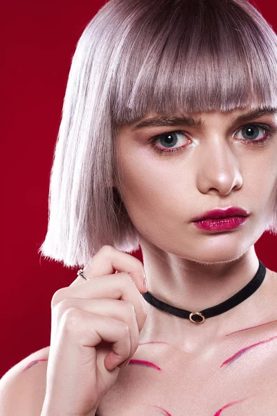 Sarı saçları ve makyaj kırmızı arka plan ile güzel kız