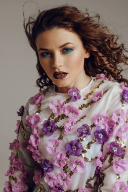 Güzel kız makyaj, saç stili ile ve arka plan üzerinde çiçekli elbise