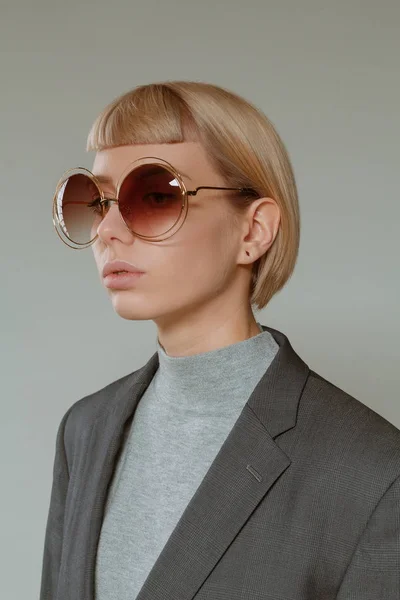 Blonde girl with short hair style in fashion glasses
