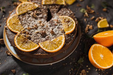 Portakal ve fındık üzerinde karanlık bir arka plan ile güzel ve lezzetli çikolatalı kek