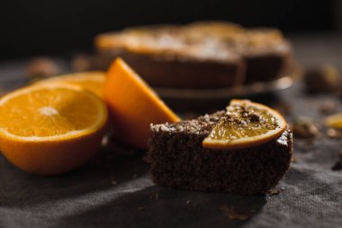 Portakal ve fındık üzerinde karanlık bir arka plan ile güzel ve lezzetli çikolatalı kek