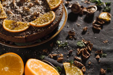 Portakal ve fındık üzerinde karanlık bir arka plan ile güzel ve lezzetli çikolatalı kek