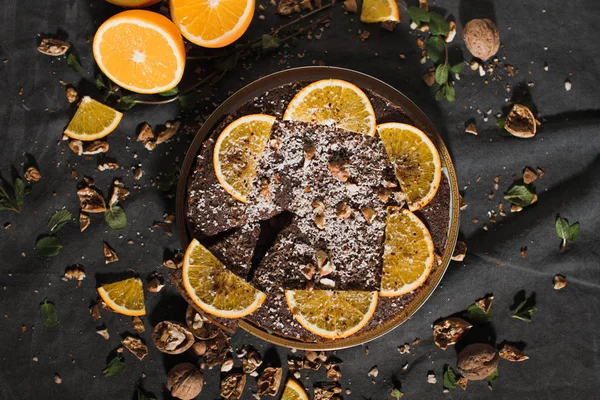 オレンジと暗い背景にナットの美しい おいしいチョコレート ケーキ — ストック写真