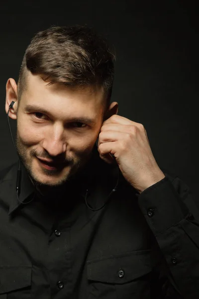 Mann Mit Kopfhörer Und Schwarzem Hemd Auf Schwarzem Hintergrund — Stockfoto