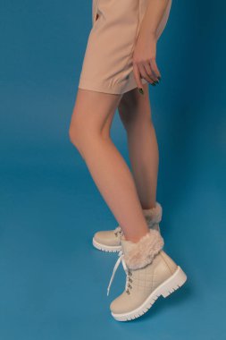 Güzel kız kış pürüzsüz bacaklar ile mavi bir arka plan üzerine çizme