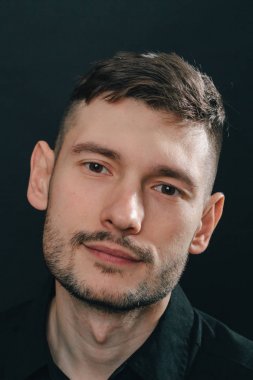 Adam kulaklık ve bir siyah arka plan üzerine siyah gömlek