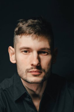 Adam kulaklık ve bir siyah arka plan üzerine siyah gömlek