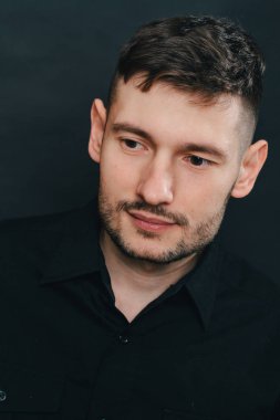 Adam kulaklık ve bir siyah arka plan üzerine siyah gömlek