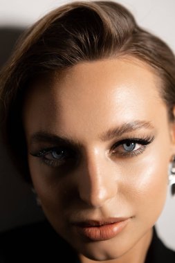 Makyajlı ve stil sahibi güzel bir kadının portresi. Mavi gözler, şık kaşlar ve güzel dudaklar..