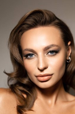 Makyajlı ve stil sahibi güzel bir kadının portresi. Mavi gözler, şık kaşlar ve güzel dudaklar..