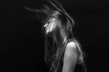 Makyajlı ve siyah arka planda uzun düz saçlı güzel bir kız.