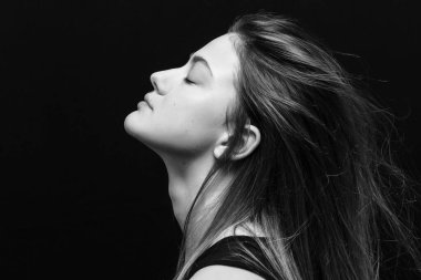 Makyajlı ve siyah arka planda uzun düz saçlı güzel bir kız.