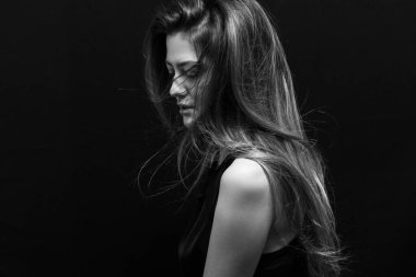 Makyajlı ve siyah arka planda uzun düz saçlı güzel bir kız.