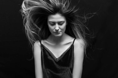 Makyajlı ve siyah arka planda uzun düz saçlı güzel bir kız.