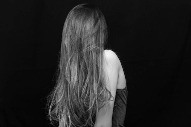 Makyajlı ve siyah arka planda uzun düz saçlı güzel bir kız.