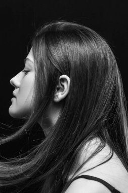 Makyajlı ve siyah arka planda uzun düz saçlı güzel bir kız.
