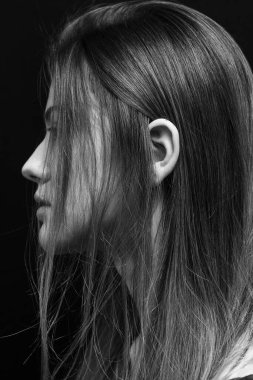 Makyajlı ve siyah arka planda uzun düz saçlı güzel bir kız.