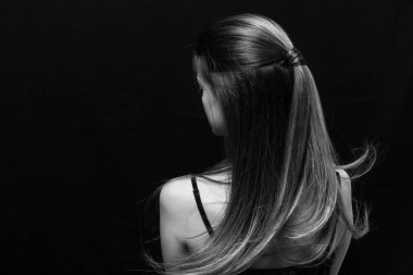 Makyajlı ve siyah arka planda uzun düz saçlı güzel bir kız.