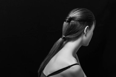 Makyajlı ve siyah arka planda uzun düz saçlı güzel bir kız.