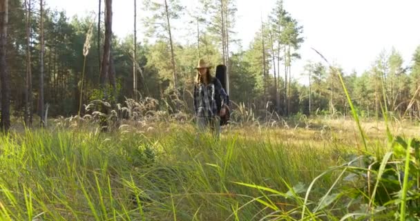 Joven con guitarra clásica camina en el bosque — Vídeos de Stock