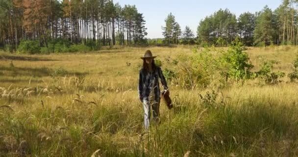 Ung man med klassisk gitarr promenader i skogen — Stockvideo