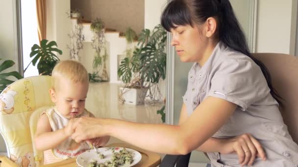 Mother teaches her son to use fork, to eat with fork — Stock Video