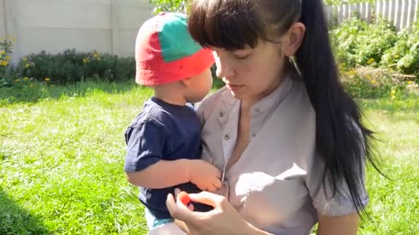 Mutter füttert ihren Sohn mit Himbeere. Kind isst Himbeere — Stockvideo