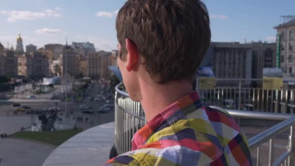 Jongeman neerkijkt op straat, plein, verkeer, auto's, mensen. Kiev, Oekraïne — Stockvideo
