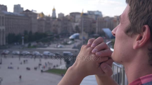 Young man is looking in the sky above city — Stock Video