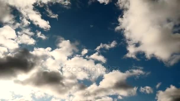 Sun moves on blue sky. Lens flare. Sun rays shine through white clouds. Time lapse — Stock Video