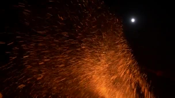 Chispas y cenizas por la noche. Luna en el fondo — Vídeo de stock