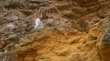 Olgun kadın deniz kenarında uçurumun kenarına egzersizleri yapıyor