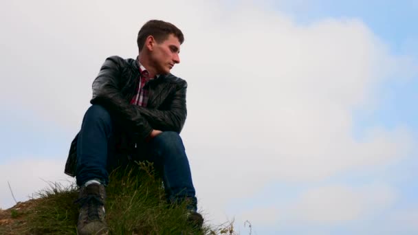 Νεαρός Άνδρας Κάθεται Στην Άκρη Του Γκρεμού Ψάχνει Για Θάλασσα — Αρχείο Βίντεο