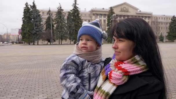 快乐的母亲握着孩子的手 微笑着 慢动作秋天冬天城市 — 图库视频影像