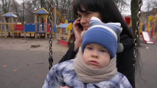 Smiling Happy Mother Her Child Swing Playground Slow Motion Winter — Stock Video