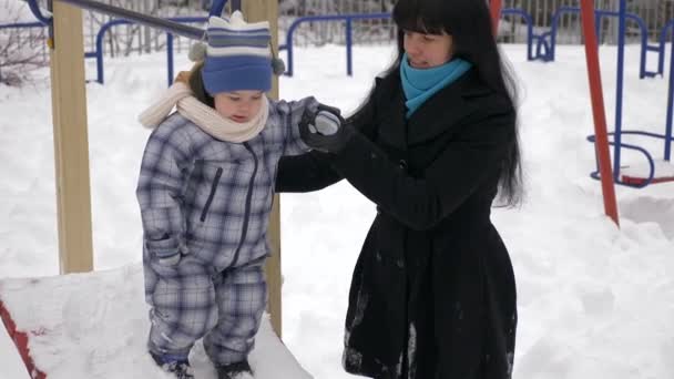 Gelukkig Moeder Speelt Met Haar Kind Sneeuw Bedekt Speeltuin Slow — Stockvideo