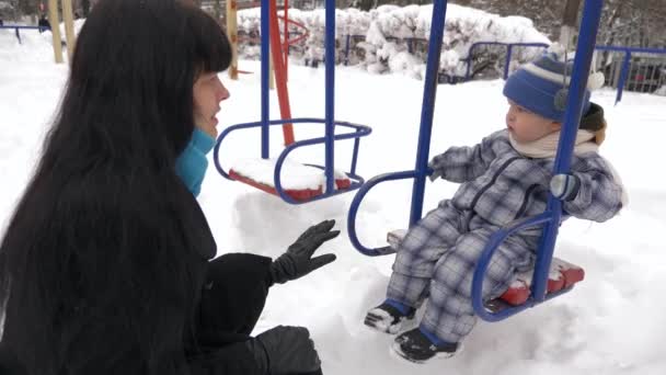 Mãe Feliz Brinca Com Seu Filho Parque Infantil Coberto Neve — Vídeo de Stock