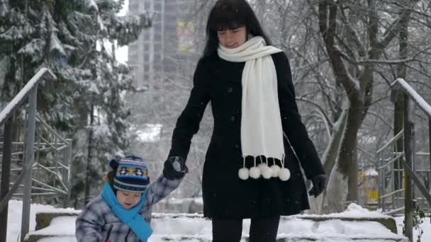 快乐的妈妈带着孩子下楼走 积雪覆盖 雪降慢动作 — 图库视频影像