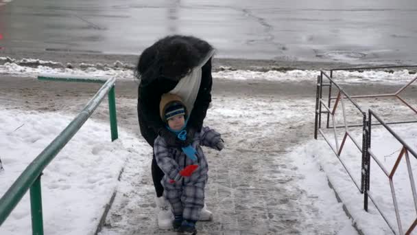 Junge Schöne Mutter Und Niedliches Kind Gehen Bei Schneefall Freien — Stockvideo