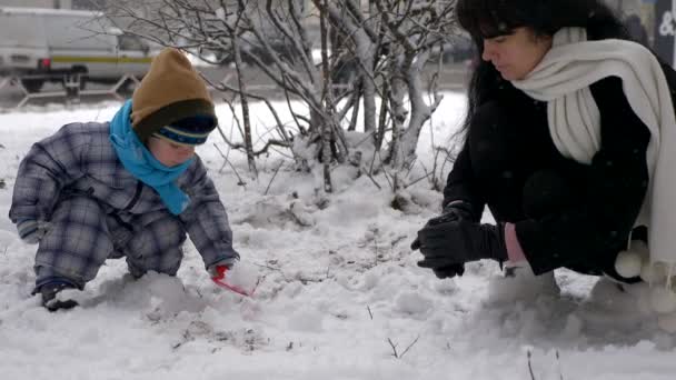 Giovane Bella Madre Carino Bambino Giocare All Aperto Durante Nevicata — Video Stock